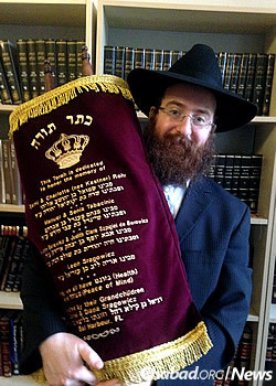Rabbi Pinny Weinman, co-director of Chabad of Edinburgh, holds the Torah for use by Jewish students at the university (Photo: Bais Yisroel Torah Gemach)
