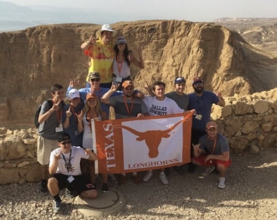 Students join Rabbi Zev Johnson to show their Longhorn pride atop Masada. June 2016