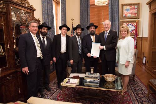 Arkansas Gov. Asa Hutchinson displays the “Education and Sharing Day” proclamation at a ceremony attended by Chabad-Lubavitch emissaries based in the capital of Little Rock. From left are: State Rep. Charlie Collins, Rabbi Ben Tzion Pape, Mendel Ciment, Rabbi Yosef Kramer, Rabbi Pinchus Ciment, Hutchinson and State Rep. Robin Lundstrum (Photo: Randall Lee/Office of the Governor)