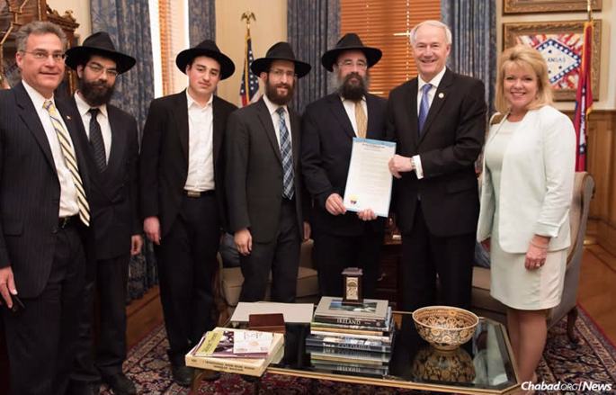 Arkansas Gov. Asa Hutchinson displays the “Education and Sharing Day” proclamation at a ceremony attended by Chabad-Lubavitch emissaries based in the capital of Little Rock. From left: State Rep. Charlie Collins, Rabbi Ben Tzion Pape, Mendel Ciment, Rabbi Yosef Kramer, Rabbi Pinchus Ciment, Hutchinson and State Rep. Robin Lundstrum (Photo: Randall Lee/Office of the Governor)