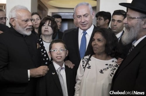 Moshe Holtzberg thanks Sandra Samuel, second from right, for saving his life as Prime Minister Narendi Modi of India and Prime Minister Benjamin Netanyahu of Israel look on. Joining them are Moshe's maternal grandmother, Yehudit Rosenberg, and his paternal grandfather, Rabbi Nachman Holtzberg, right. (Photo: AFP Photo/Pool/Atef Safadi)