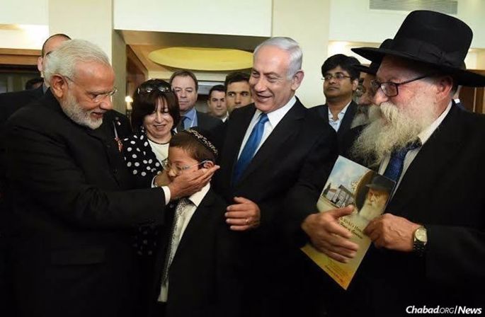 Prime Minister of India Narendra Modi meets Moshe Holtzberg, who survived a 2008 terrorist massacre in Mumbai that took the lives of his parents, Chabad-Lubavitch emissaries Rabbi Gavriel and Rivka Holtzberg. Among those looking on are Moshe’s paternal grandmother, Fraida Holtzberg; Prime Minister Benjamin Netanyahu of Israel; and Moshe’s grandfathers, Rabbi Nachman Holtzberg, second from right, behind Rabbi Shimon Rosenberg, right.