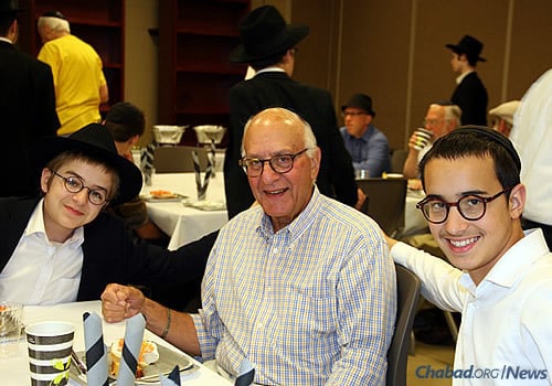 Shea Shmotkin and Sholom Schonbuch sit with Jerry Eisenshtadt at a Sunday brunch celebrating the efforts of the “Friday boys.”