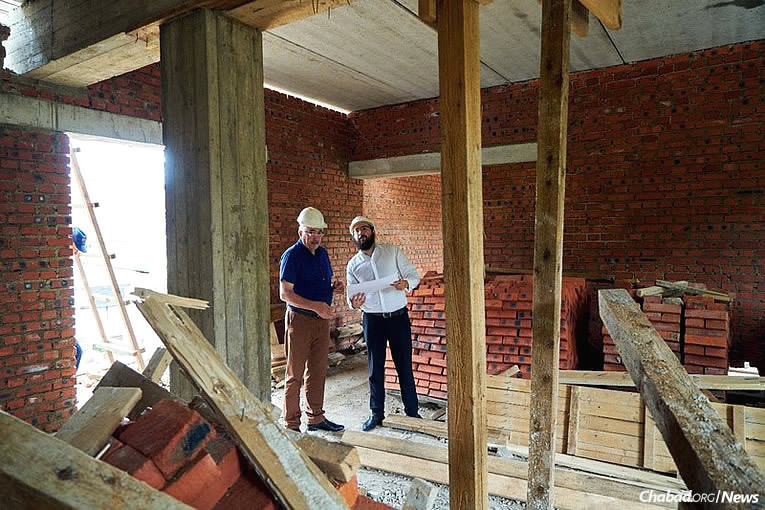 Rabbi Eliyahu Riss, chief rabbi of the Jewish Community of Birobidzhan, goes over building plans for the construction of a mikvah in the famous Yiddish-speaking city in Russia’s Far East. (Photo: Jewish Community of Birobidzhan)