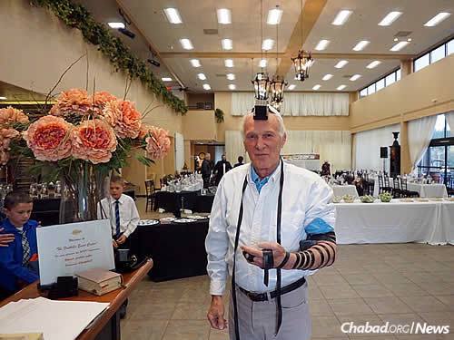 A local resident takes the opportunity to put on tefillin before the Passover seder in April, after not having worn it for many years.