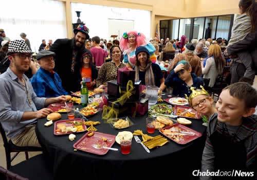 The rabbi, third from left, talks to guests at the Purim celebration, which drew 150 people.