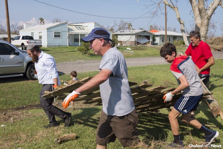 Schmukler, left, is accompanied by volunteers Dr. David Ryan, center left, Alex Ryan and Mitch Stuart, far right, who work to remove debris from a local home in Rockport. (Photo: Verónica G. Cárdenas/Chabad.org)