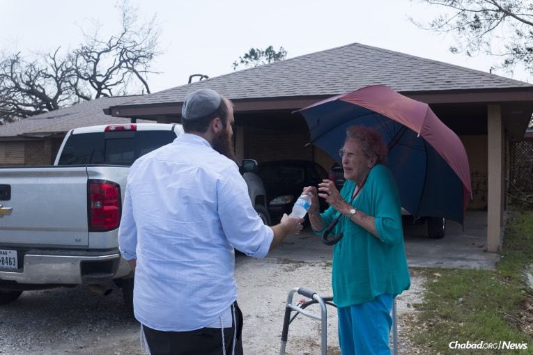 Schmukler brings water to a woman affected by Hurricane Harvey in Rockport. (Photo: Verónica G. Cárdenas/Chabad.org)