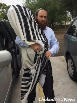 Rabbi Naftali Schmukler of Corpus Christi takes a Torah scroll to safety after being ordered to evacuate on Friday.