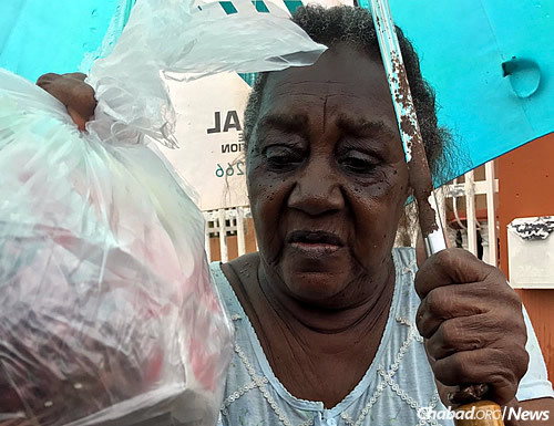 A woman accepts a bag of items.