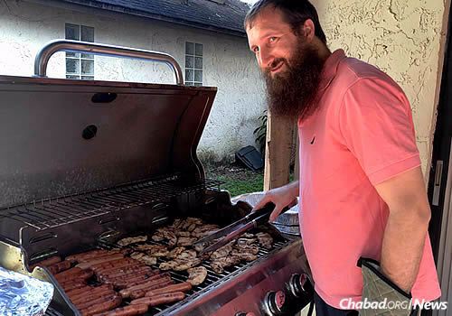 Rabbi Pinny Backman, co-director of Chabad at the University of South Florida in Tampa, grills up a barbecue meal for students.