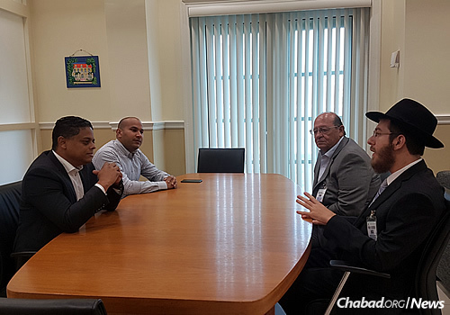 The rabbi, right, and Ivan Becher, to his right, meet with the prime minister of Cura&#231;ao, Eugene Rhuggenaath, at left.