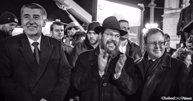 Andrej Babis, Premier ministre de la République tchèque, à gauche, et l’ambassadeur d’Israël en République tchèque Daniel Meron, à droite, entourent le Rav Manis Barash à l’allumage de Prague mardi 12 décembre, la première nuit de la fête de ‘Hanouka. (Photo : Karl Cudlín)