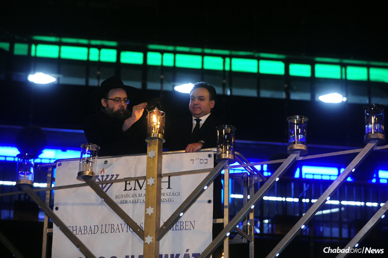 Rabbi Boruch Oberlander, left, director of Lubavitch of Hungary, and violinist Zolt&#225;n M&#225;ga usher in the initial of daily celebrations related to the 20th anniversary of Chanukah menorah-lightings in Budapest, on Tuesday, Dec. 12, the first night of the eight-day holiday.