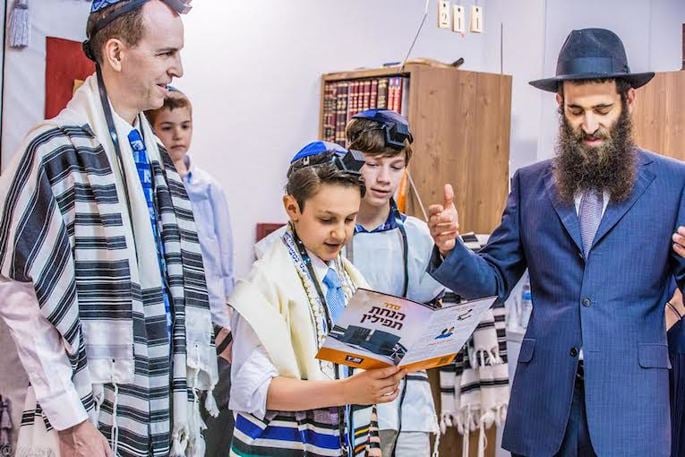 A bar mitzvah celebration can include many rituals, such as putting on tefillin. (Maitri Shah Photography)