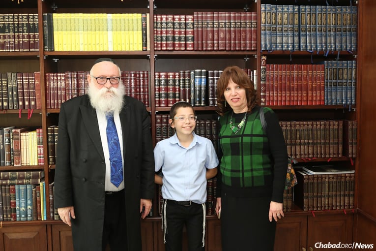 In the Nariman House library with his maternal grandparents, Rabbi Shimon and Yehudit Rosenberg. (Photo: Chabad of Mumbai/Chabad.org)
