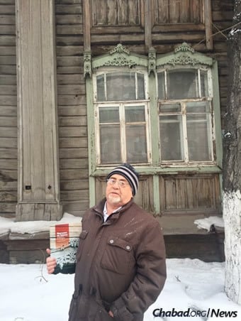 Tomsk Jewish historian David Kuzhner holds a book he wrote on the Jewish history of the Siberian city outside the Soldiers’ Synagogue.