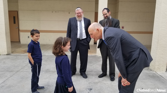 The meeting was held on Monday morning at Chabad of Coral Springs. Scott was greeted by students from Hebrew Academy Community School in nearby Margate, where Denburg (left, looking on) serves as dean.