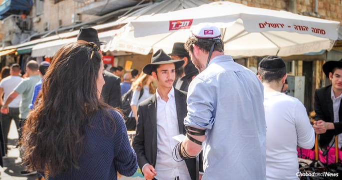 The tefillin stand in the center of the Machane Yehuda open-air market in Jerusalem is one of the smallest yet busiest Chabad centers in the world. (Photo: Aviad Tevel)