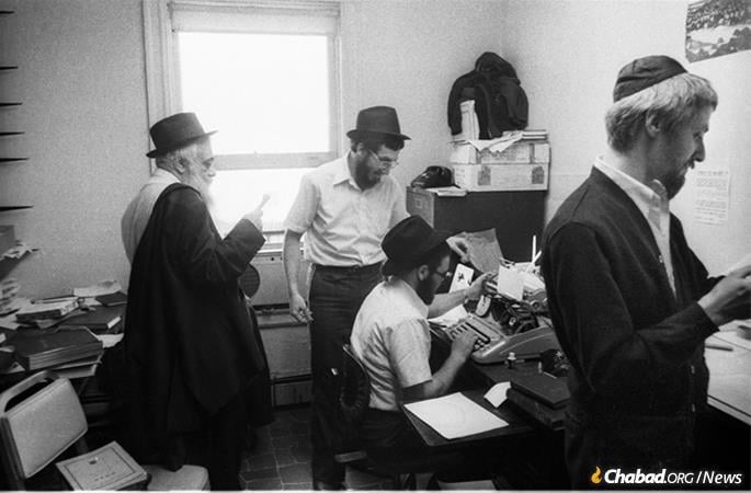 R&#39; Yoel Kahn, left, can be seen reviewing notes of a farbrengen in an office at 770 in 1979. (Photo: JEM/The Living Archive)
