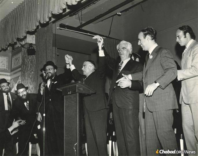 Taking on a leadership role in the Crown Heights Jewish community in the mid 1970s, he developed a warm relationship with Mayor Abe Beame. Fogelman, fourth from left, holds hands with Beame at a victory party in Crown Heights. (Photo: Fogelman family collection)