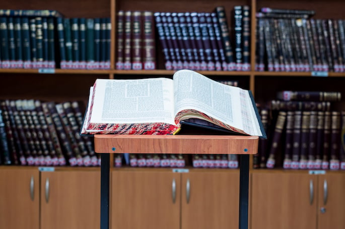 O Talmud é uma coleção de escritos que abrange a plena escala de lei e tradição judaica. O povo judeu devota muito tempo para estudar o Talmud. Visto aqui está um volume aberto do Talmud.