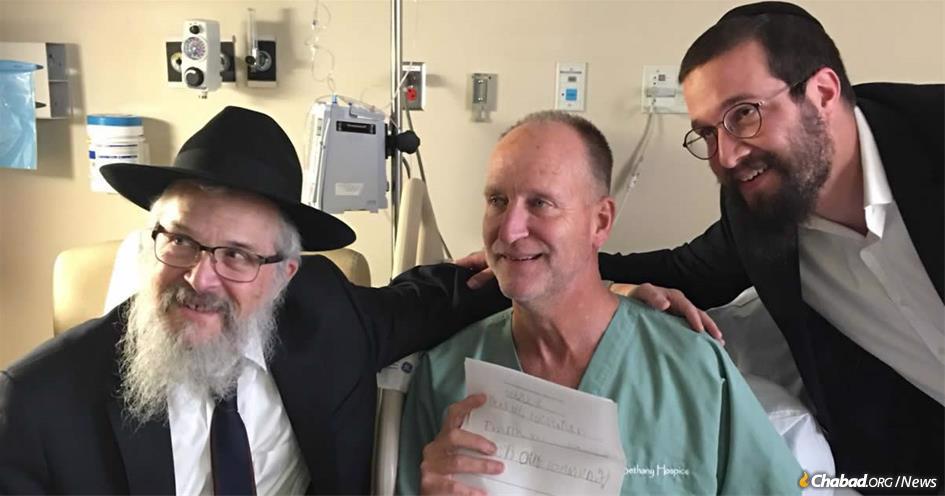 Officer Dan Mead, center, holds a letter of thanks from second-grade students at Yeshiva Schools of Pittsburgh. He is flanked by Rabbi Yisroel Rosenfeld, left, and Rabbi Henoch Rosenfeld.