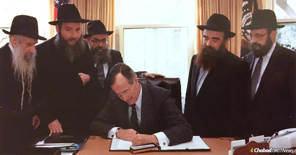 President George H.W. Bush signing an “Education Day” proclamation. Looking on are (from left) Rabbi Menachem Shmuel Dovid Raichik, Rabbi Shlomo Cunin, Rabbi Shimon Lazaroff, Rabbi Abraham Shemtov and Rabbi Moshe Feller.