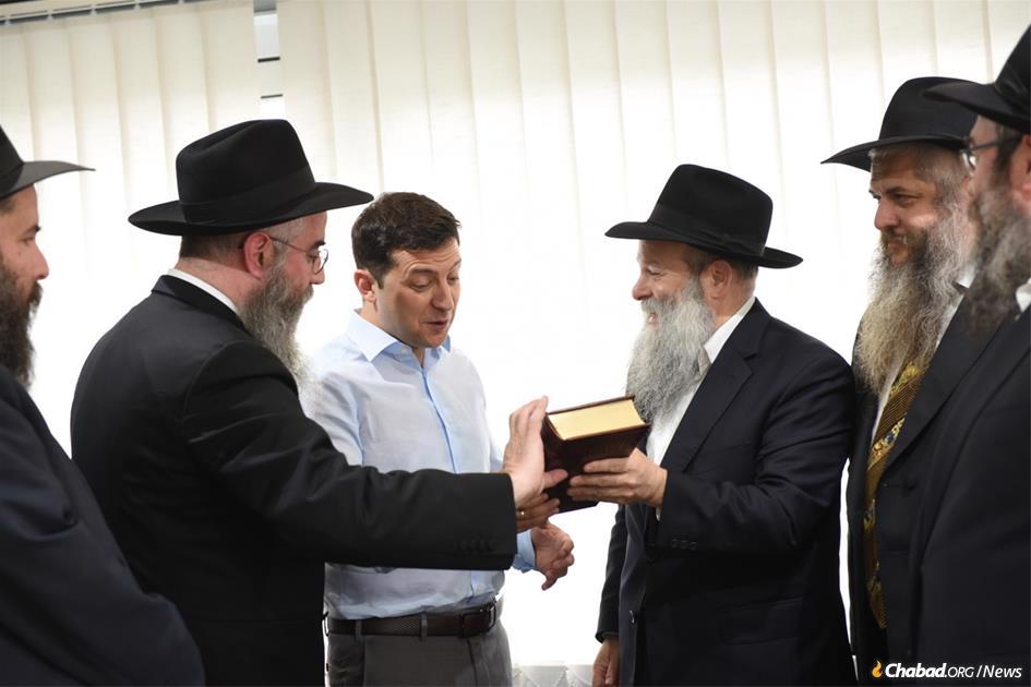  President-elect Volodymyr Zelensky, Ukraine's first-ever Jewish president, held a high-profile meeting with Ukraine's regional chief rabbis on May 6. Here, the comedian-turned-politician is presented with a Chumash in Russian translation by Rabbi Shmuel Kaminezki and Rabbi Avraham Wolff, as other members of the delegation look on.