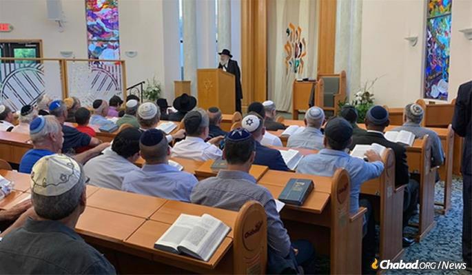 Rabbi Yisroel Goldstein, who was shot and wounded at the Chabad of Poway synagogue a week earlier, addresses the congregation prior to the onset of the following Shabbat, when hundreds turned out for services and a communal dinner.