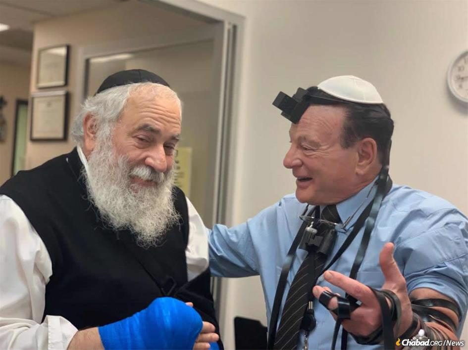 When Rabbi Yisroel Goldstein, left, learned that his surgeon, Dr. Yale Kadesky, the son of Holocaust survivors, had never put on tefillin, he offered to rectify the situation. The result: an impromptu bar mitzvah in the surgeon’s office.