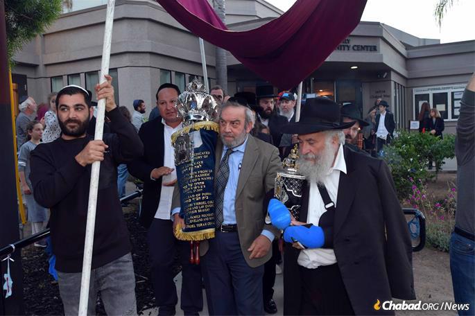 After the final letters in the scroll were written, Dr. Howard Kaye and Rabbi Yisroel Goldstein led a parade through the streets, carrying the finished Torah.