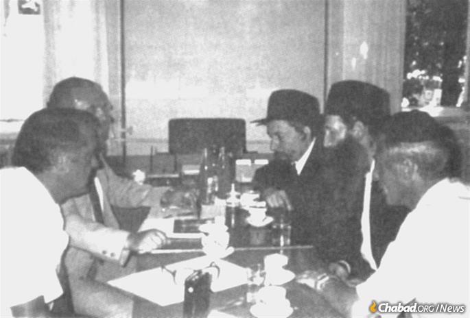 Rabbi Yitzchak Kogan and Rabbi Sholom Ber Levine (second and third from right, respectively) meet with KGB officials in Kiev on Aug. 7, 1991.