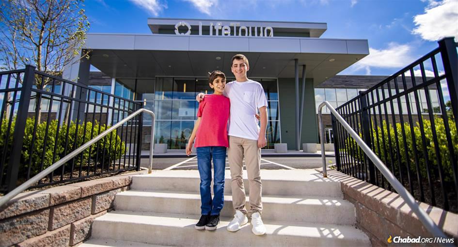 The $18 million LifeTown center celebrates its grand opening on Sept. 9 in Livingston, N.J. A project of Friendship Circle of New Jersey, the center is built on young people volunteering to assist children with special needs, like Eitan Shua, left, and Kyle Fink. (Photo: Mendel Grossbaum)