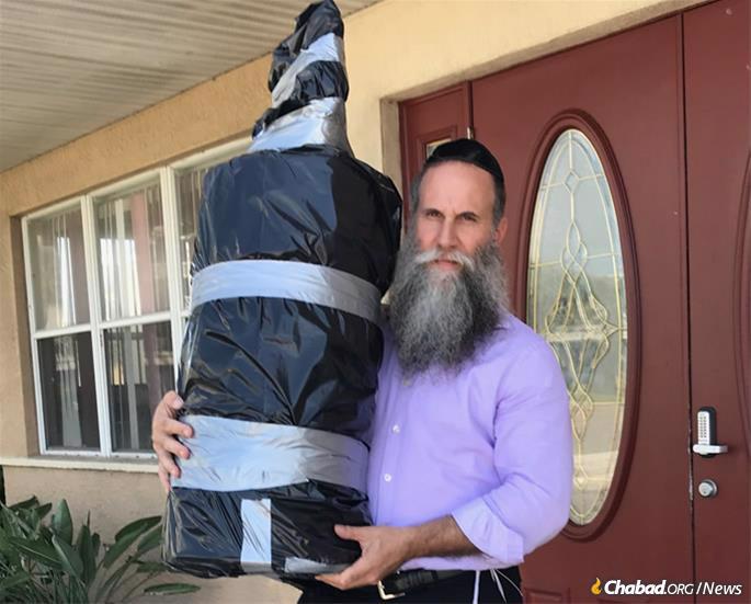 Rabbi Zvi Konikov with one of three Torah scrolls being transported off Satellite Beach, the barrier beach where Chabad of the Space & Treasure Coasts is located, and onto the Florida mainland for safekeeping.