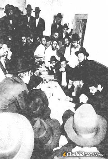 Rabbi Shlomo Cunin and Rabbi Yosef Aharonov lead a farbrengen with yeshivah students in New York following their historic August 1991 private audience with the Rebbe.