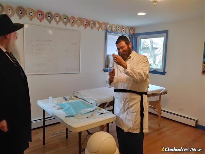 Rabbi Levi Heber, who flies to Chicago from New York once or twice a month to perform circumcisions, prepares for the brit milah.