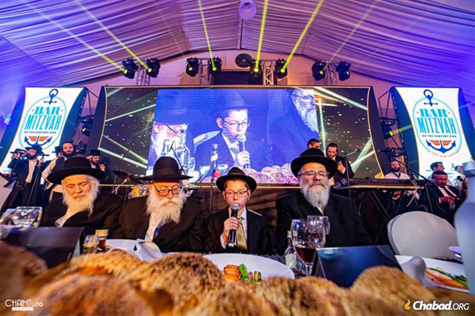 Flanked by the grandfathers who helped raise him, Moshe recites the traditional Chassidic bar mitzvah discourse.