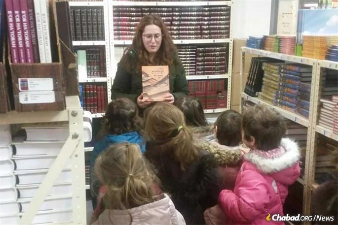 The Rebbe encouraged people of all ages to mark Hei Tevet by buying or reparing Jewish books, then studying them. A group of young girls with their teacher in Kehot&#39;s showroom. (Photo: Kehot Publication Society)