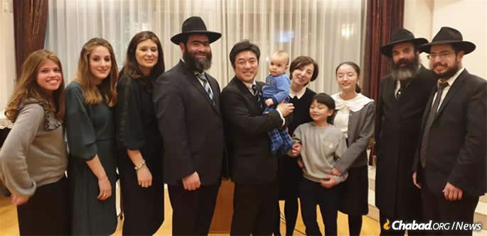 Japan&#39;s State Minister for Foreign Affairs Yasuhide Nakayama and family with Chabad of Japan emissaries at a Chanukah event at the Israeli embassy in Tokyo. From left: Rachel Vaisfiche, Batya Vishedsky, Chana Sudakevich, Rabbi Shmuel Vishedsky, the Nakayamas, Rabbi Mendi Sudakevich, Rabbi Shalom Vaisfiche.