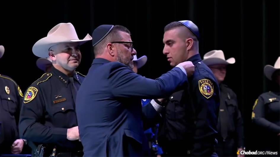 Seth Frydberg was sworn in as the newest deputy sheriff in Bexar County, Texas, with the help of his father, Felix Frydberg, center, the son of Holocaust survivors, as Sheriff Javier Salazar, left, looked on.