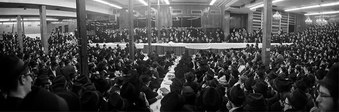 The Rebbe, Rabbi Menachem M. Schneerson of righteous memory, leads a farbrengen in the main synagogue of 770, Shevat 1976.