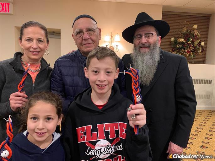 Rabbi Anschelle Perl and guests at the Havdalah ceremony at the conclusion of Shabbat in Mineola, N.Y.