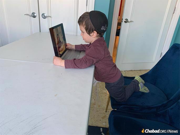 A preschool student at Oholei Torah interacts with his teacher via computer at home. Jewish schools in Crown Heights closed temporarily due to COVID-19 on Friday, March 13. By Monday, they were shuttered.