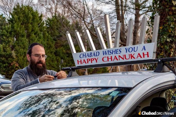 The Greensboro parade, which typically includes 40 vehicles, will wend its way from the local Chabad center, directed by Rabbi Yosef and Hindy Plotkin, to downtown where a giant menorah will be lit. Here, Rabbi Plotkin outfits his car. (Photo: Ivan Cutler)