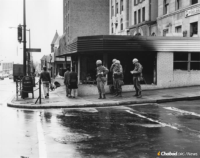 Members of the U.S. military stands watch on a street corner amid violence and rioting in Washington, D.C., 1968. (Credit: District Department of Transportation Historic Collections via Wikimedia Commons)