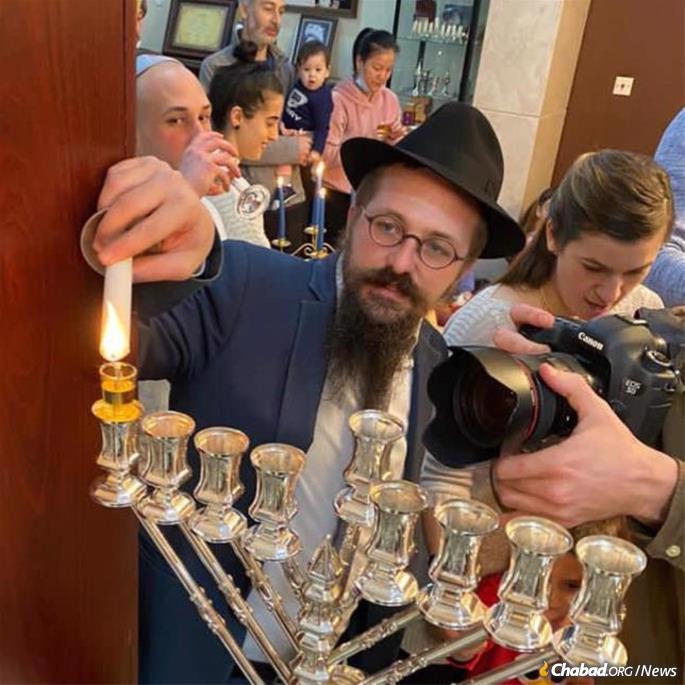 Rabbi Dovi Henig lights the menorah at a Hanukkah party at Chabad of Chengdu, China.