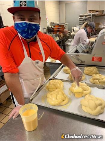 Jacob Gross puts the finishing touch on each challah before baking them.