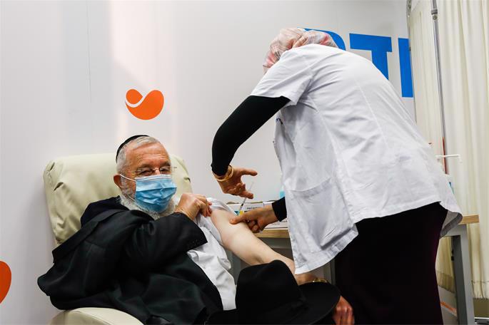 An Israeli citizen receives a Covid-19 vaccine, at Meuhedet Covid-19 vaccination center in Jerusalem, on December 21, 2020. Photo by Olivier Fitoussi/Flash90