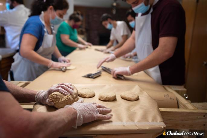 The dough at the Texas Shmurah Matzah Bakery in Fort Worth, Texas, is rapidly divided and rolled into round, thin discs, seen here on Monday, March 15, 2021. (Photo: Ben Torres for Chabad.org)
